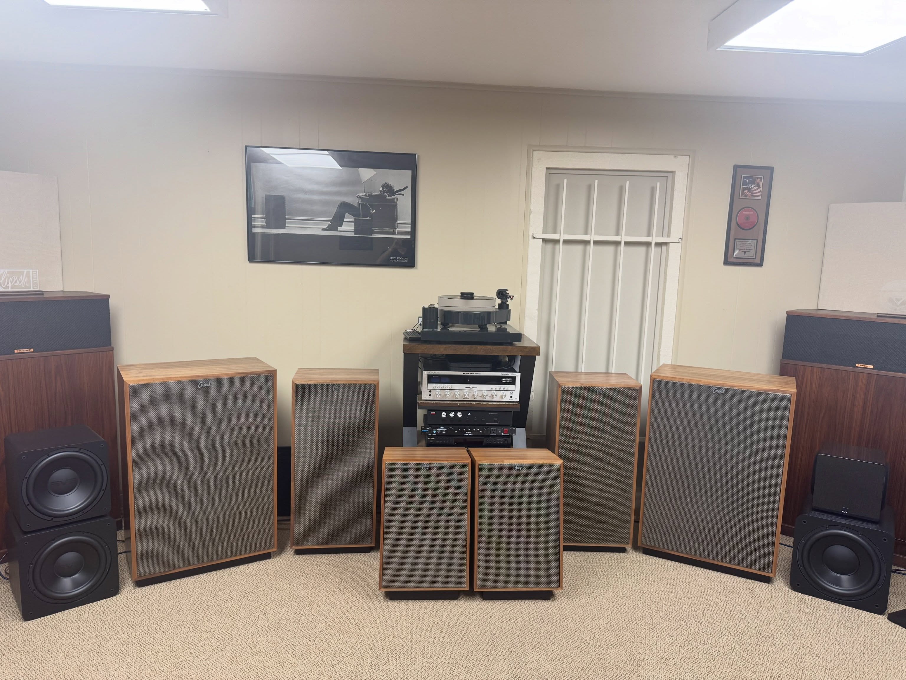 Wood-cabinet speakers arranged around a stereo system in the Speakerworks listening room